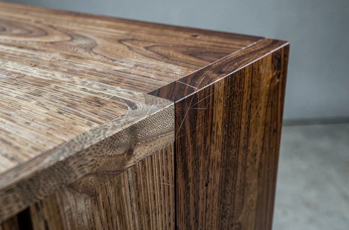 Détail de finition à l'huile de tung sur un meuble en noyer vintage restauré, comparaison bois brut et traité